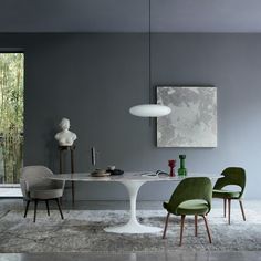 a dining room with grey walls and green chairs