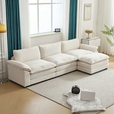 a living room with white furniture and blue curtains