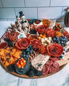 a platter filled with different types of cheeses and meats on top of a table