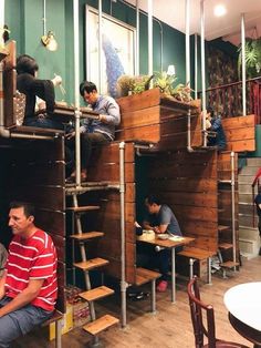 people are sitting at tables in a restaurant with wooden walls and ladders to the ceiling