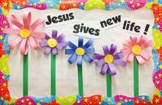 a bulletin board with paper flowers and the words jesus gives new life