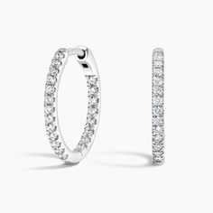 a pair of hoop earrings with diamonds on the inside and outside of each earring