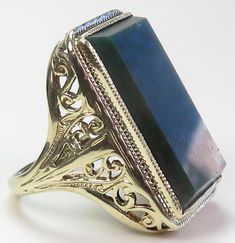 This stunning antique cocktail ring from the 1920s features a beautiful bloodstone with a green and red speckled emerald shape, set in a 13K green gold filigree setting. The ring is handcrafted and adjustable, with a ring size of 6 UK-L1/2. The oval shape of the main stone adds an elegant touch to this vintage piece, perfect for any occasion such as weddings, anniversaries, birthdays, or even holidays like Christmas, Mother's Day, and Valentine's Day. The ring is signed and has no known origin, Friendship Theme, Antique Cocktail Ring, Filigree Ring Gold, Right Hand Rings, Art Deco Period, Art Deco Era, Gold Filigree, Filigree Ring, Green And Red