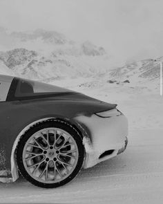 a black and white photo of a car in the snow