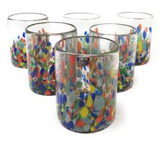 four glass cups with different colored dots on them