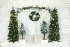 a white brick wall with christmas decorations and wreaths on it