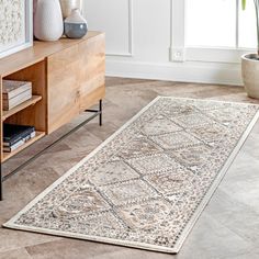 a living room area with a rug on the floor and vases next to it