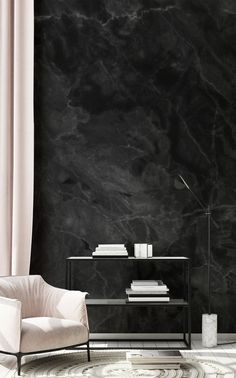 a living room with black marble walls and flooring, a white chair in the foreground