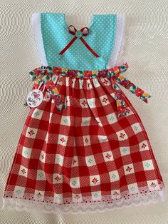 a red and white checkered dress with two pairs of scissors on the top of it