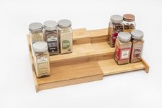 a wooden tray with spice jars on it and spices in the bottom one is empty