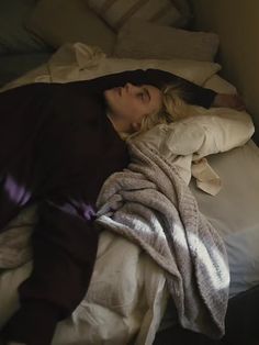 a woman laying in bed under a blanket