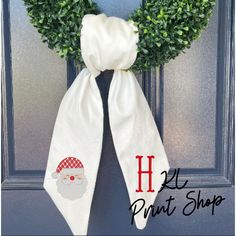 a door hanger with a christmas wreath and santa claus's hat on it