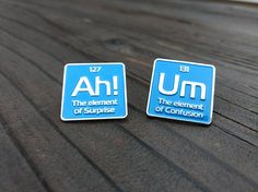 two blue square magnets with the words ah and the element of confusion on them