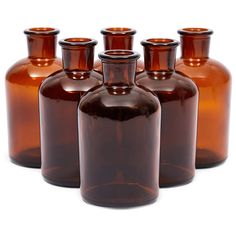 six brown glass bottles are lined up in a row