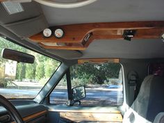 the interior of a vehicle with wood trim and gauges mounted to the dash board