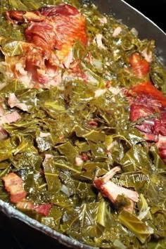 a pan filled with greens and meat on top of a stove next to a wooden spoon