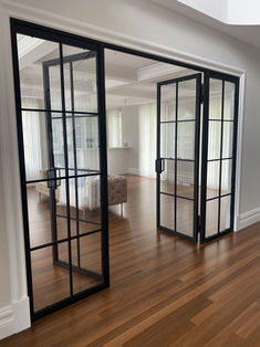 an empty room with wooden floors and glass doors