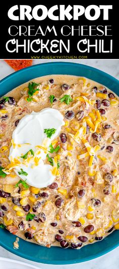 a blue bowl filled with chicken chili and topped with sour cream