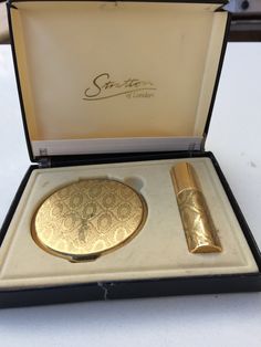 This Vintage Stratton Set with Compact and matching perfume atomizer have matching gold designs. The compact measures about 3 inches around.  The perfume atomizer is about 3 inches tall by 1/2 inch wide and is refillable. They have a lovely Mid Century retro style dating to the early 1960s. They have a beautiful gold patterned design on the lid, with the bottom and frame in gold.  The case is decorated with a gold pattern similar to a "Fleur de Lis."  There is no powder but does have a powder pu Vintage Makeup Compact, Gold Compact Mirror, Perfume Holder, Hand Held Mirror, Compact Mirror Vintage, Handheld Mirror, Cool Mirrors, Hippie Girl, Perfume Atomizer