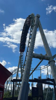 the roller coaster is going up in the sky with clouds behind it and blue skies above