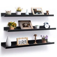 three black shelves with pictures and other items on them