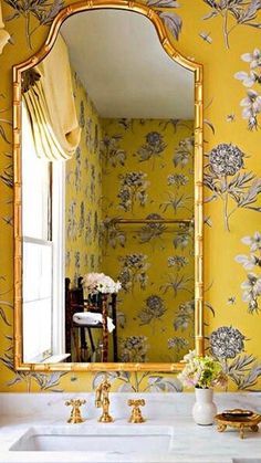 a bathroom with yellow walls and floral wallpaper