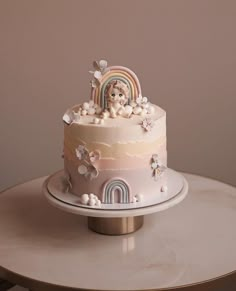 there is a cake that has a dog on top and rainbows in the background