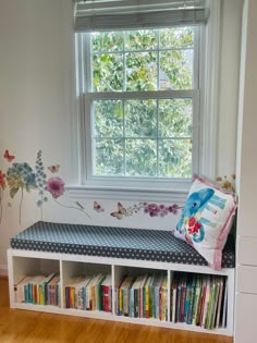 a room with a window, bookshelf and flowers on the wall