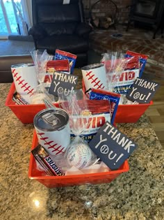 baseball themed thank you gift baskets in an orange tray on a granite countertop with a fireplace