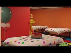 a room with two beds and balloons on the wall, one bed has a cake on it