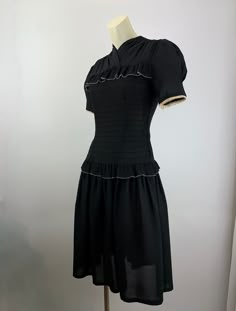 Cute 1940'S black rayon dress with a fitted bodice and a drop waist. There is this pleated flouncy trim that lines the chest and wraps around the drop waist. There is an attached belt that ties in the back. Super sweet. The sleeves are short and puffy. There is a metal talon side zipper as well as 4 cloth covered buttons in back along the neckline. The skirt is rather short and flirty, which reminds me of cute baby doll dresses. This dress is in EXCELLENT VINTAGE CONDITION... no real issues to p Puffy Sleeve Dress Vintage, 60s Summer Fashion, 90s Black Fashion, Old Hollywood Dresses, 40s Clothes, Prairie Fashion, 1940s Fashion Women, Baby Doll Dresses, Vintage 90s Dress