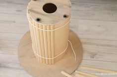 a wooden object sitting on top of a table next to some chopsticks and a cup