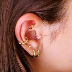 a close up of a person's ear with three different types of piercings