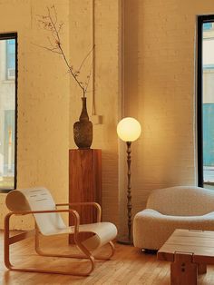 a living room filled with furniture and a tall vase on top of a wooden table