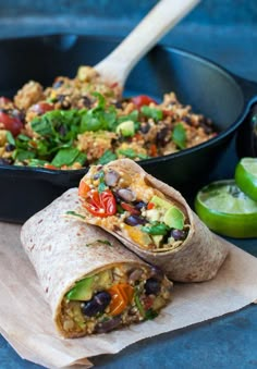 a burrito cut in half on top of a plate next to a bowl of salsa