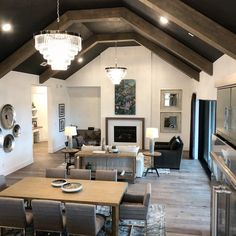 a living room filled with furniture and a chandelier hanging from the ceiling over a fire place