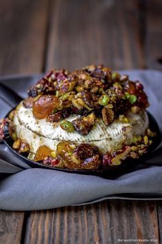 a cake with nuts and other toppings sitting on top of a cloth next to a fork