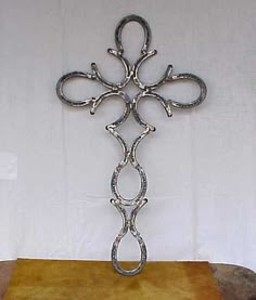 a large metal cross sitting on top of a wooden table