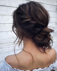 the back of a woman's head, with her hair in a low bun