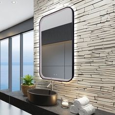 a modern bathroom with stone wall and large mirror above the sink, overlooking the ocean