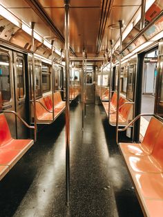 an empty subway car with orange seats