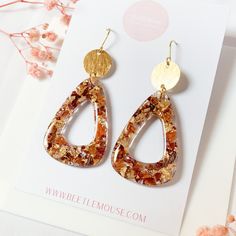 a pair of earrings sitting on top of a card