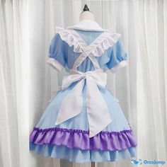 a blue and white dress with purple ruffles on the skirt is sitting on a mannequin