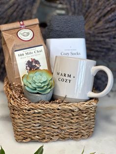 a coffee cup and some tea bags in a wicker basket with succulents