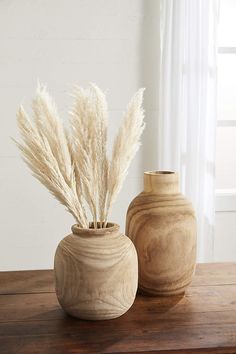 two vases sitting on top of a wooden table