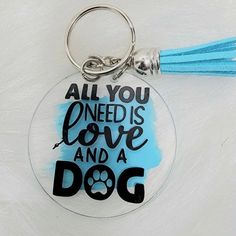 an acrylic keychain with the words all you need is love and a dog on it