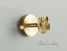 a close up of a gold door handle with a flower on the front and side