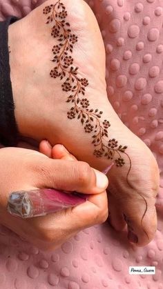 a woman is getting her hand painted with flowers