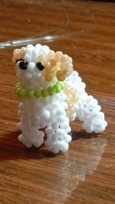 a small white dog made out of beads