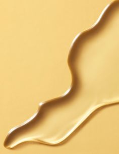 liquid flowing down the side of a yellow surface, creating a wave like pattern on it